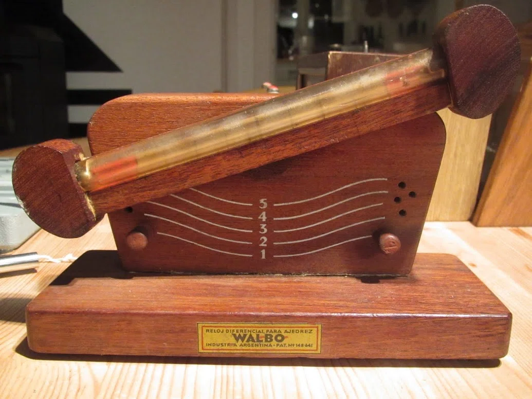 Walbo differential chess timer in a wooden base with an inclined transparent tube.